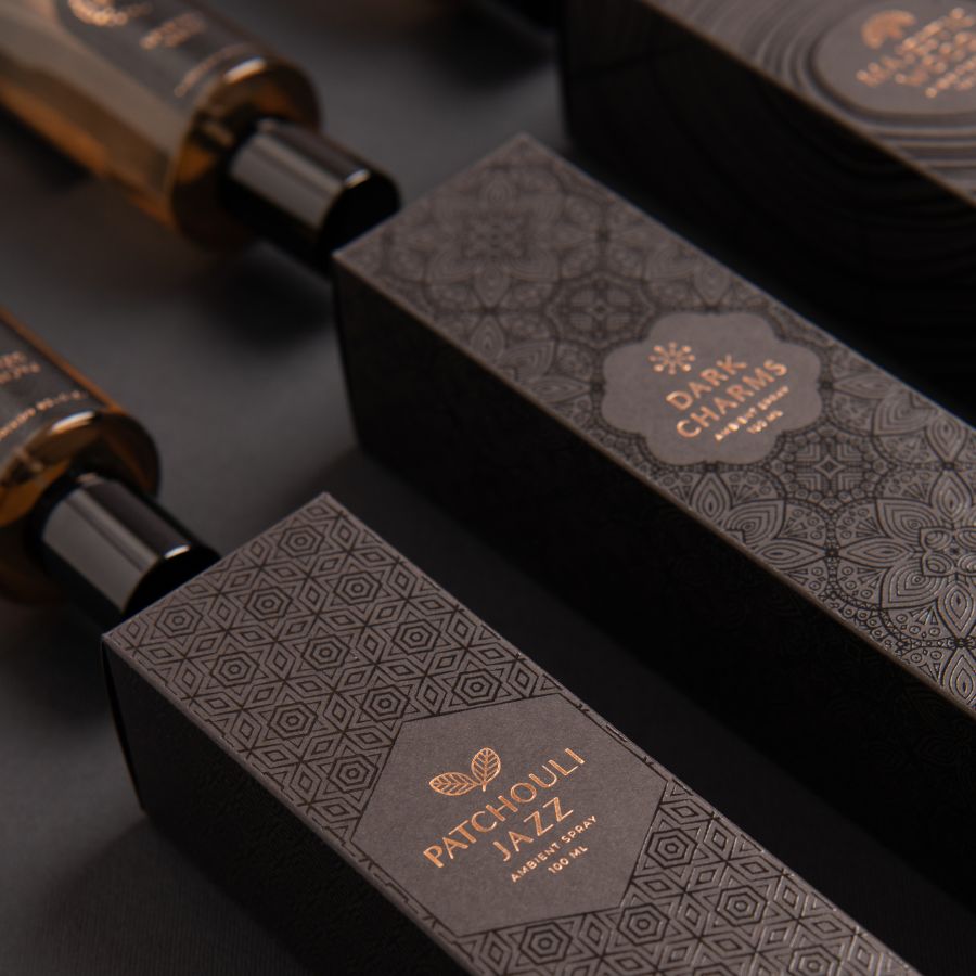 Elegant black packaging box featuring all three bronze collection ambient spray bottles on a sophisticated backdrop, highlighting their luxurious design and unique fragrances.