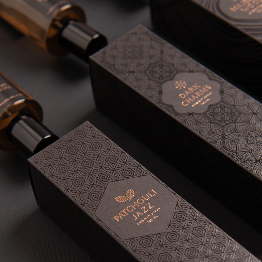 legant black packaging box featuring all three DARK CHARMS collection spray bottles on a sophisticated backdrop, highlighting their luxurious design and unique spray fragrances.