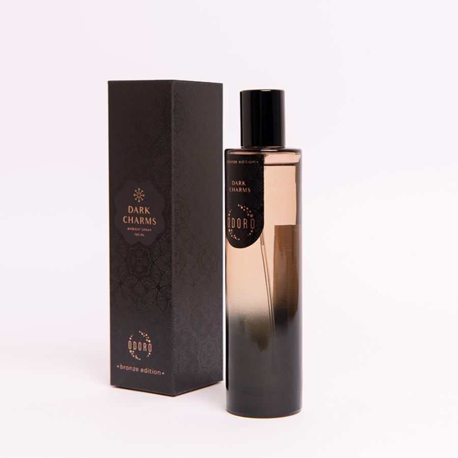DARK CHARMS spray fragrance bottle standing next to its luxurious cardboard packaging on a white background, emphasizing elegance and style.