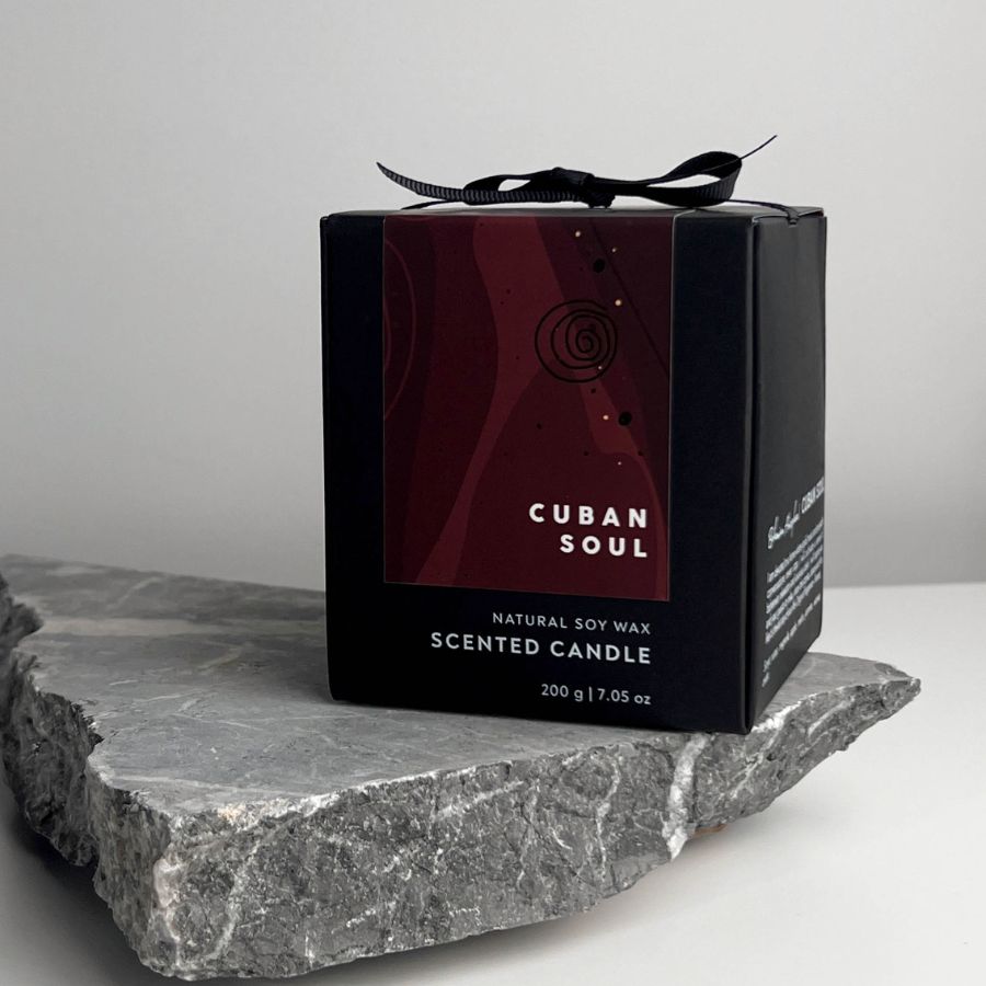 cuban Soul scented candle in its original black packaging displayed on a stone block