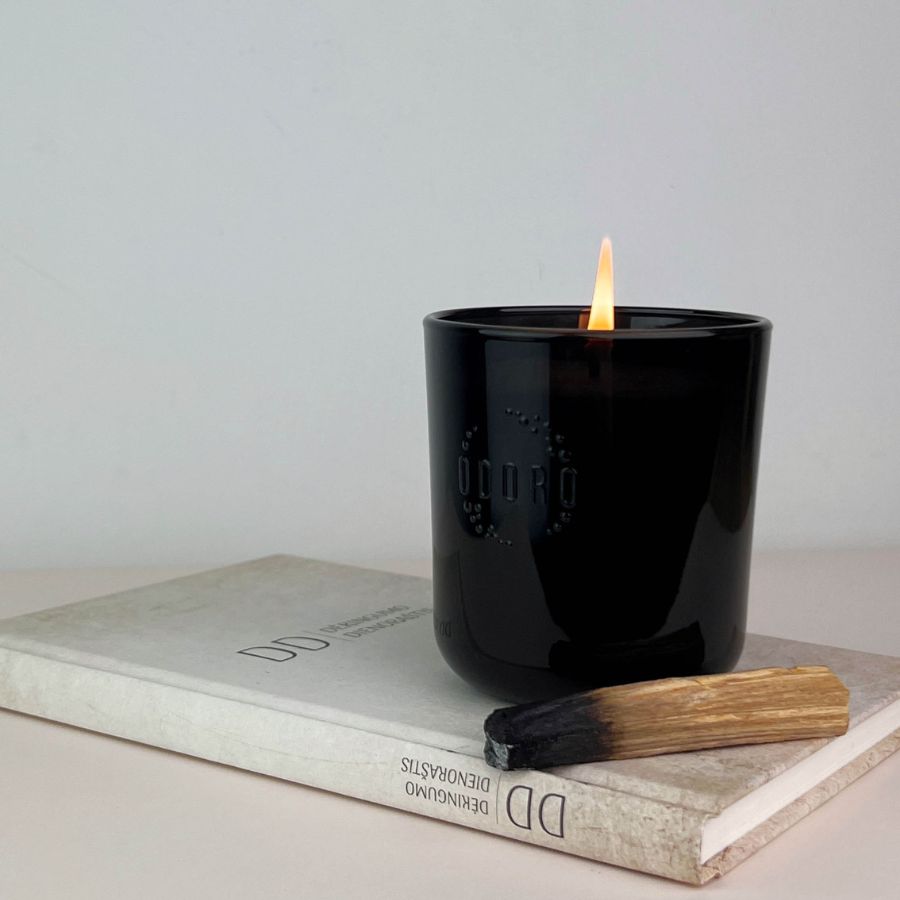 Cuban Soul scented candle burning, placed on top of a book.