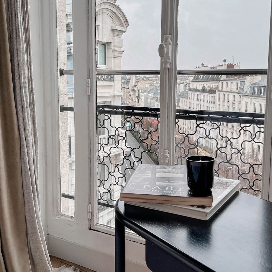 Black Magnolia candle on Paris balcony with books
