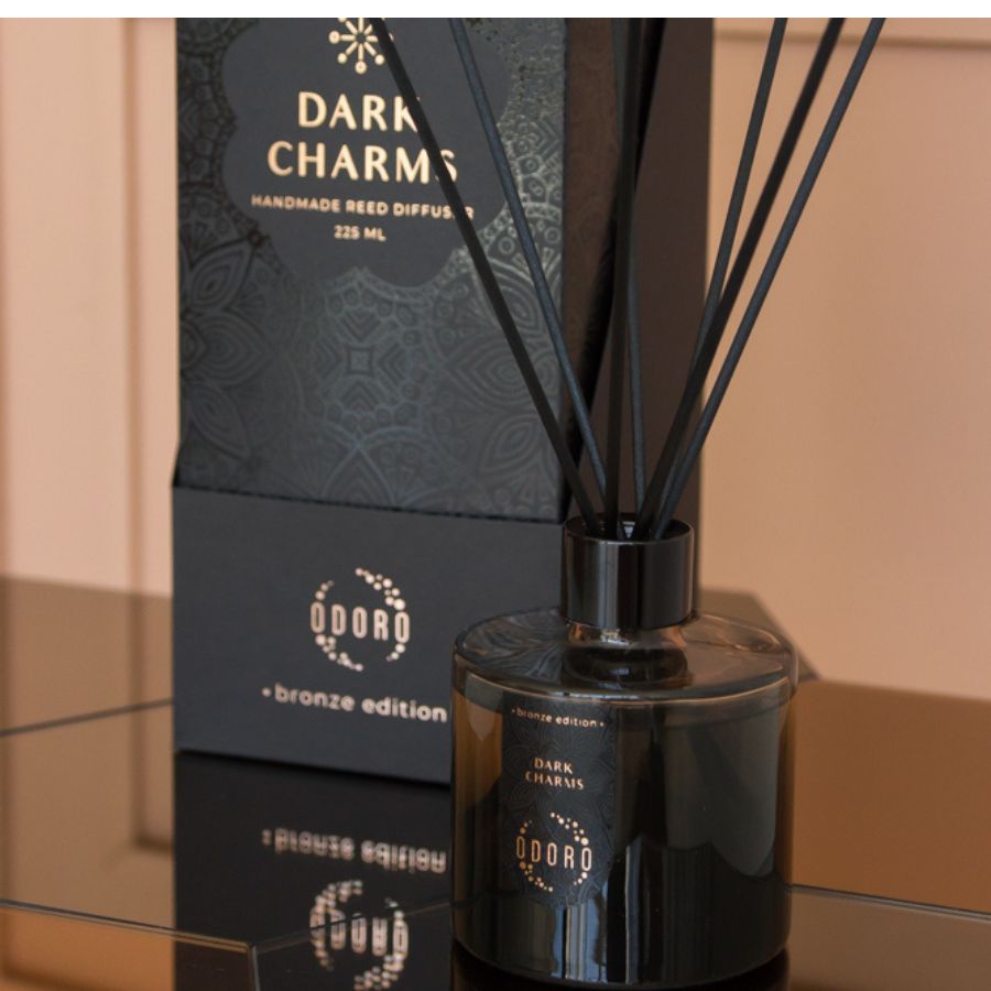 Elegant home fragrance bottle with sticks alongside its beautifully designed packaging, displayed against a neutral home backdrop, enhancing the overall aesthetic.