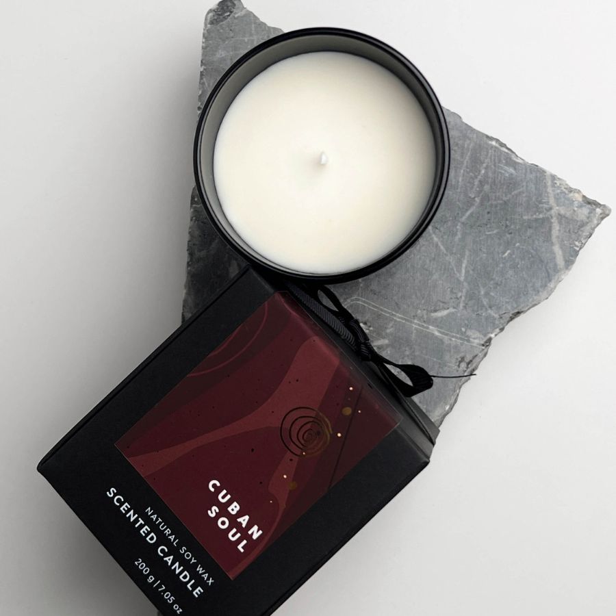 op view of Cuban Soul scented candle in black glass container with packaging.