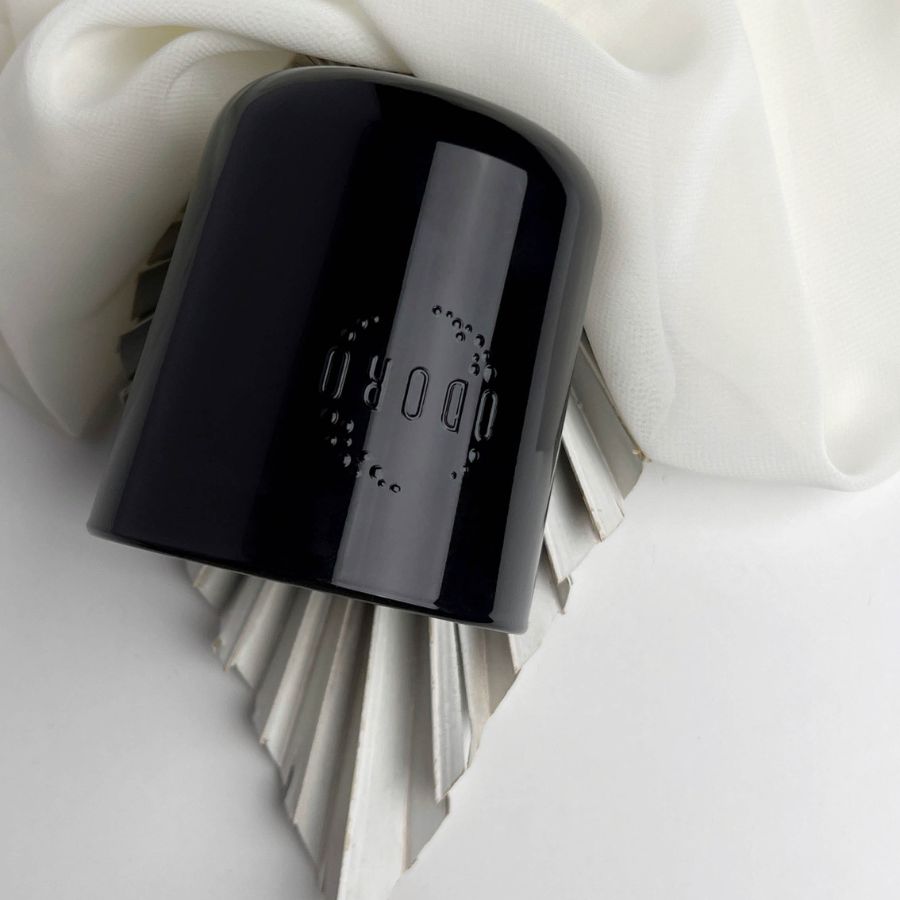 Magnolia candle inverted, displaying bottom on white fabric