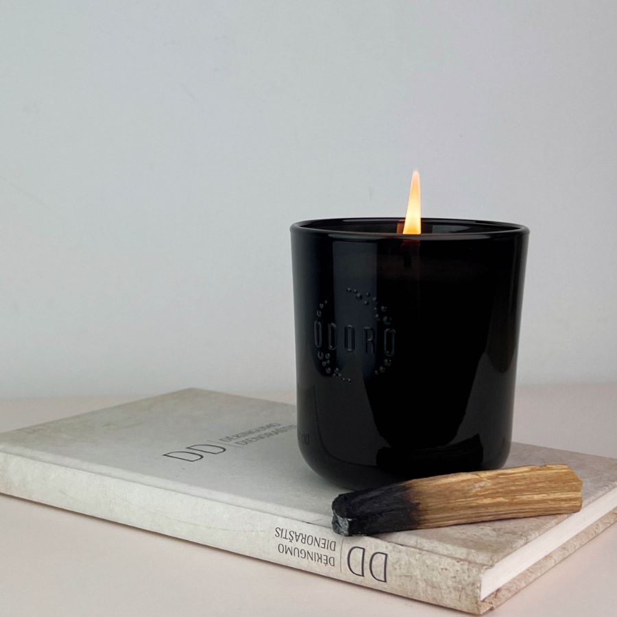 Magnolia scented candle burning on book with wooden match