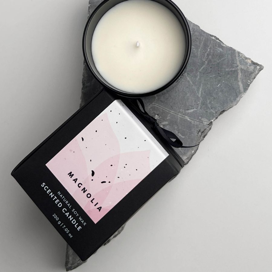 Top view of Magnolia scented candle and packaging on stone slab