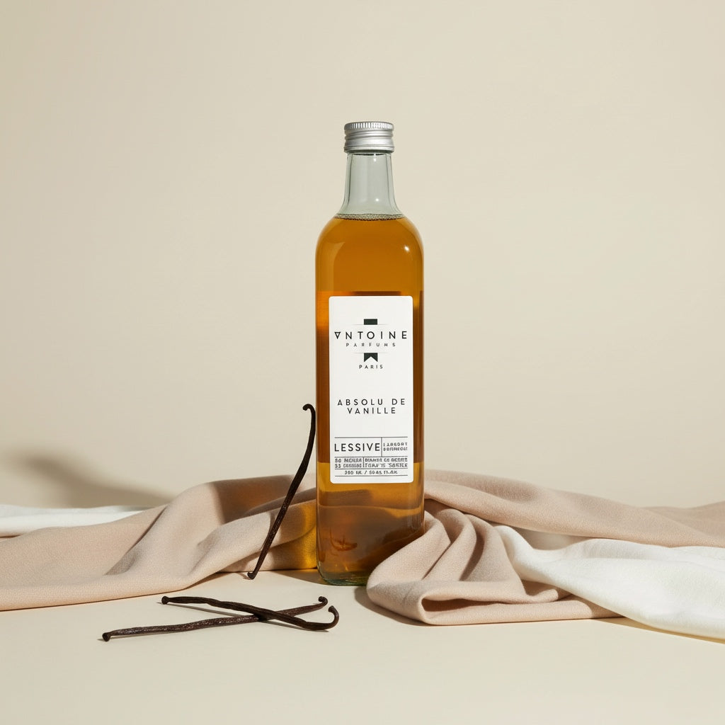 Elegant Antoine Parfums Absolu de Vanille laundry detergent on beige fabric with vanilla pods – minimalist French fragrance photo for e-shop.