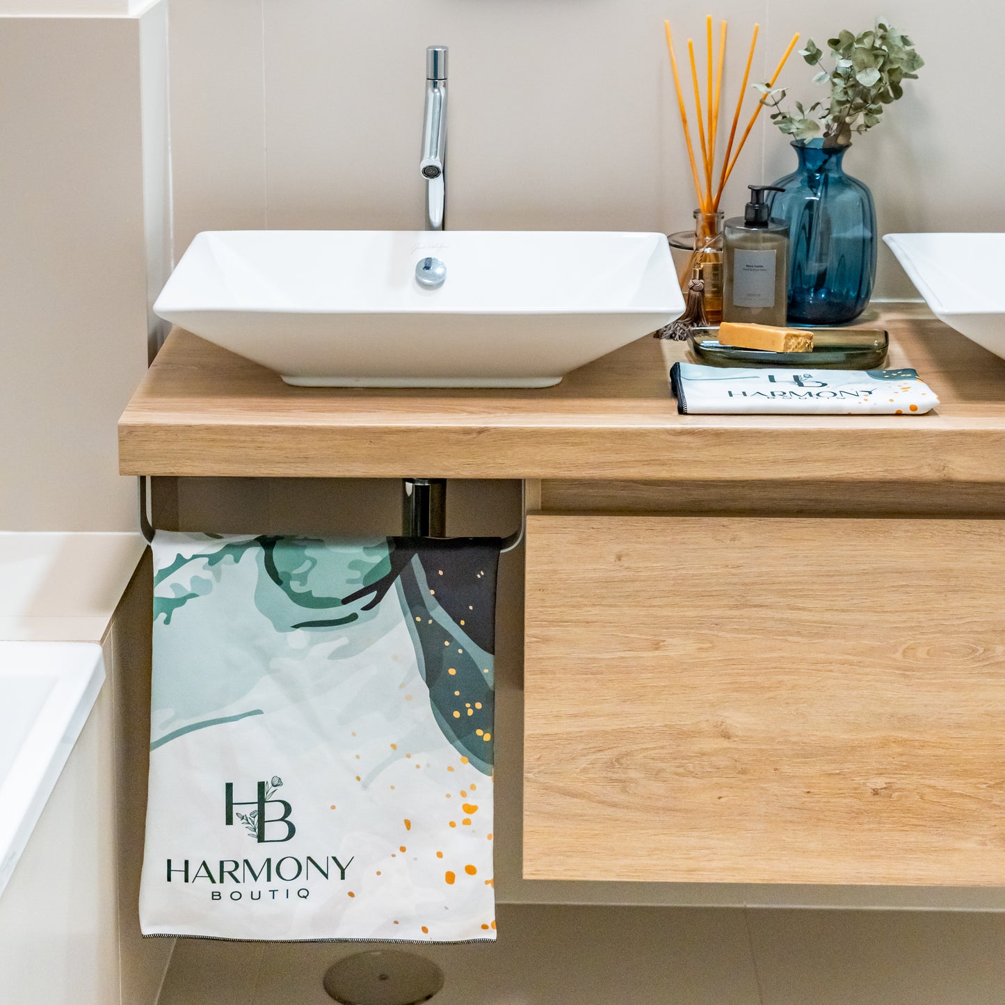 Emerald Mist towel set displayed in a modern bathroom – large towel hanging and face towel folded near the sink and spa accessories.
