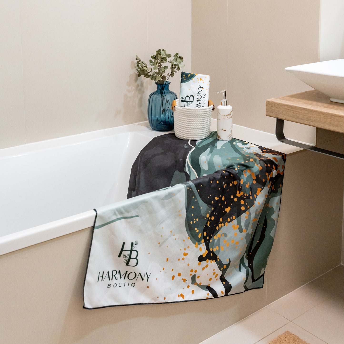 Emerald Mist towel set from Harmony Boutiq draped over a bathtub edge, complemented with minimalist bathroom decor.
