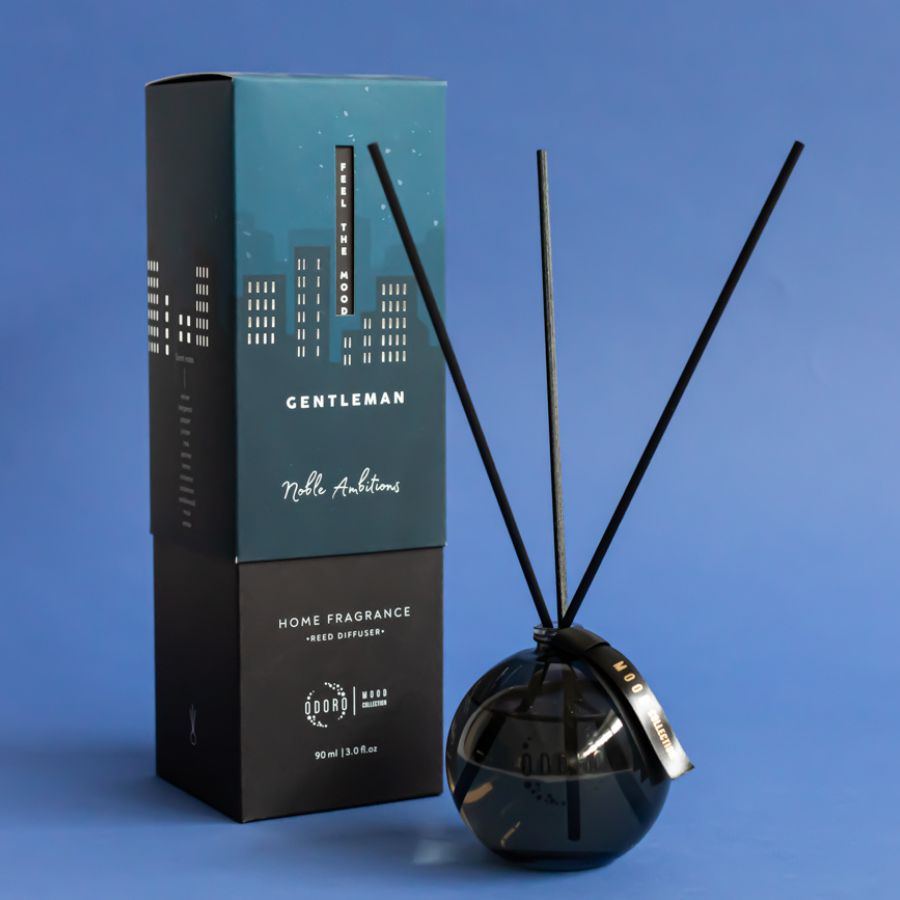 Mood Collection Gentleman reed diffuser with box and fiber sticks, set against a sophisticated blue background.