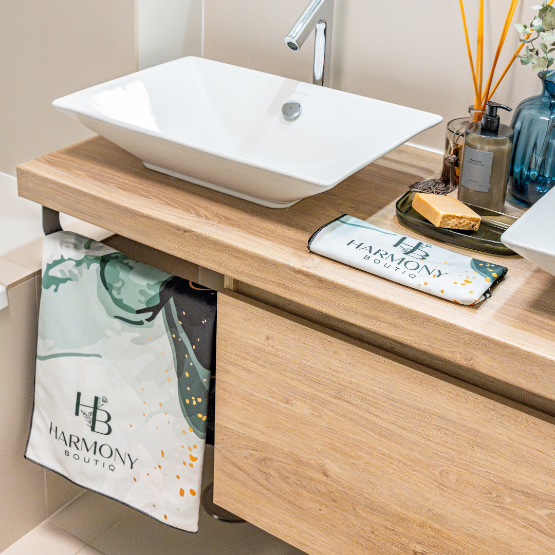 Bathroom view featuring Emerald Mist towel set – luxurious microfiber towels styled with wood cabinetry and elegant sink setup.
