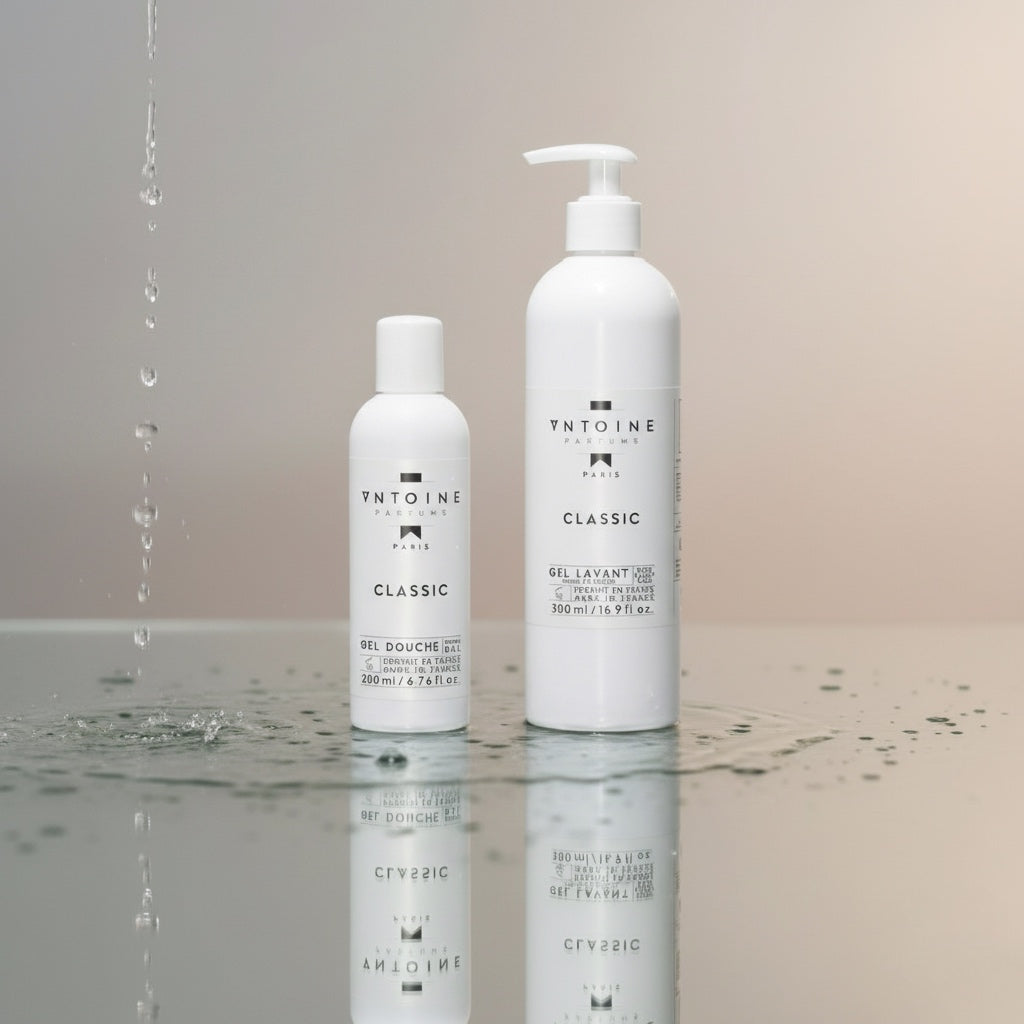 Antoine Parfums Classic hand and body wash bottles on a wet reflective surface with falling water drops – luxury French skincare aesthetic from Harmony Boutiq.