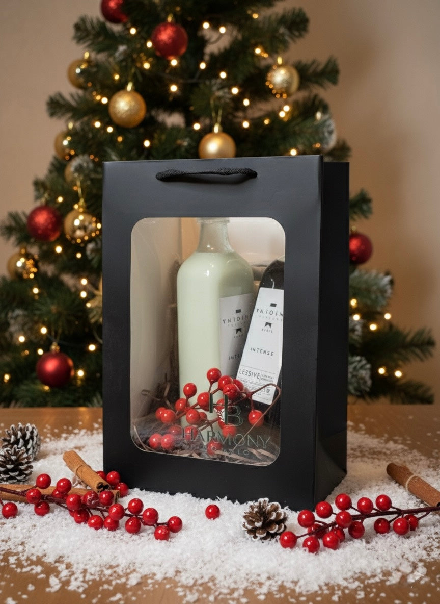 Harmony Boutiq Intense gift set with perfumed laundry detergent and softener by Antoine Parfums, elegant Christmas background with red berries and pinecones.