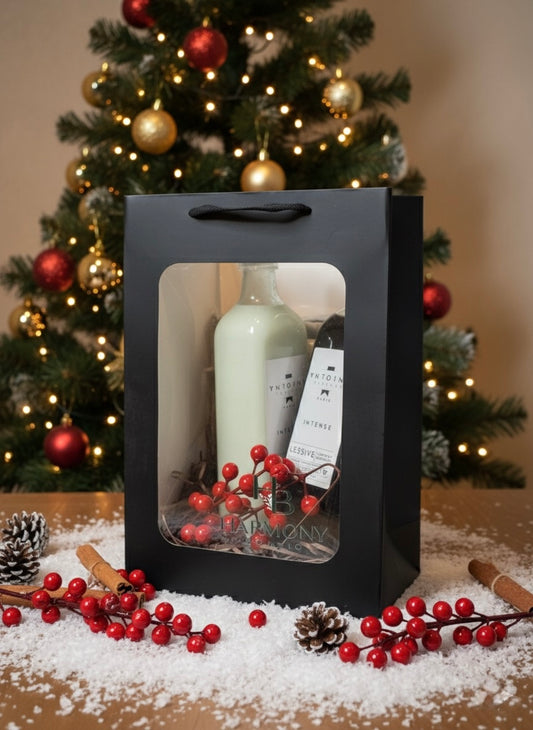 Harmony Boutiq Intense gift set with perfumed laundry detergent and softener by Antoine Parfums, elegant Christmas background with red berries and pinecones.