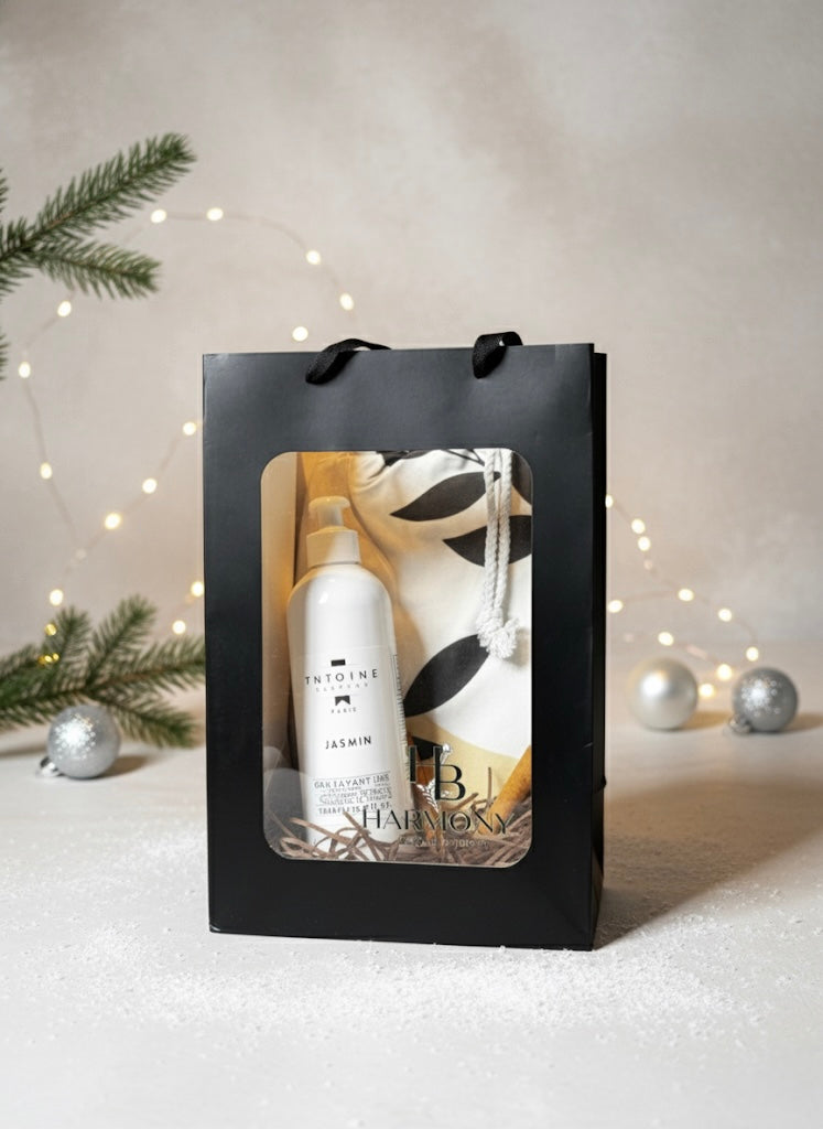 Harmony Boutiq gift set with Antoine Jasmin perfumed shower gel 500ml and large Ecovera beach or bath towel, elegant neutral background with holiday decor.