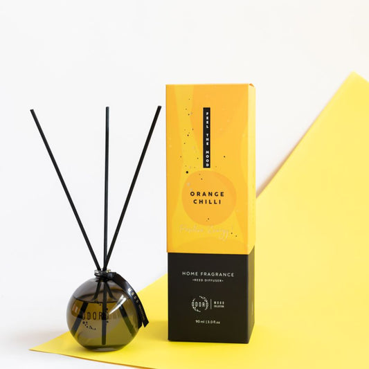 Orange Chilli reed diffuser with box, creating a vibrant and cheerful atmosphere with yellow background.